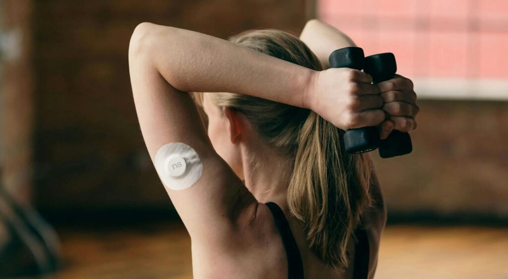 Blonde woman lifting dumbbells indoors. Fitness and health focus.